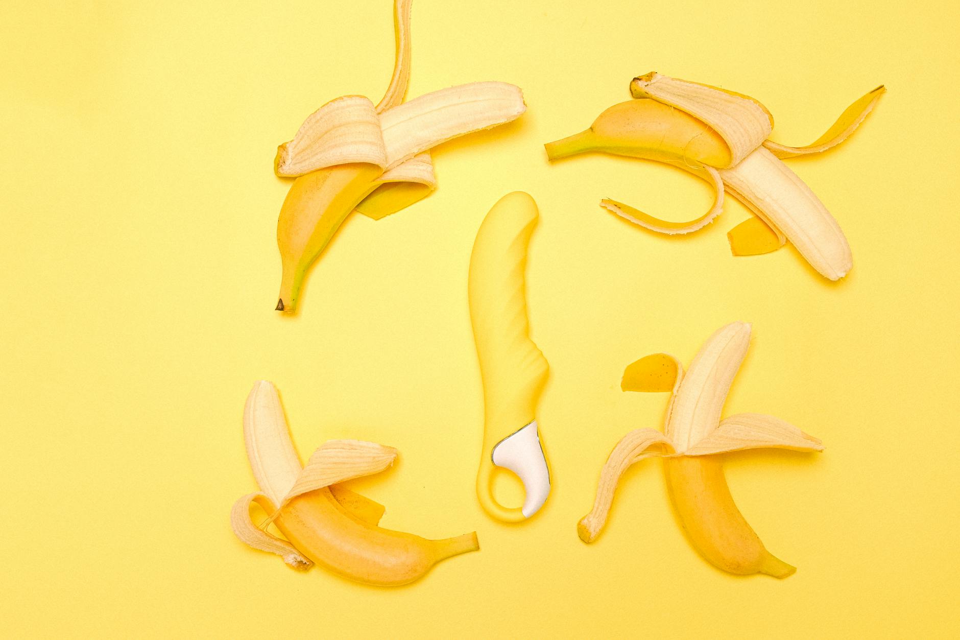 Bright yellow lemon vibrator surrounded by fresh lemons on yellow background, symbolizing reconnection and pleasure.