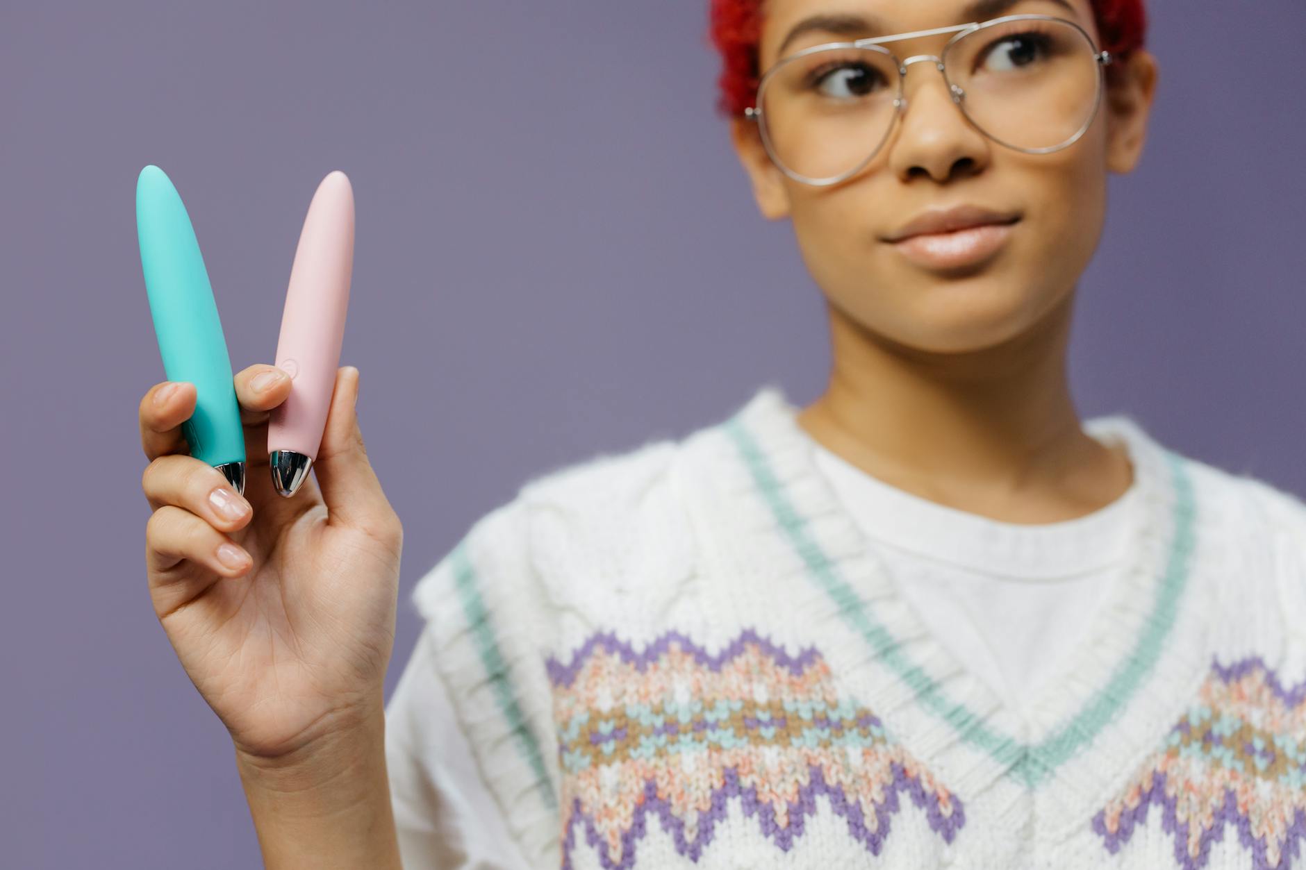 A person holding colorful vibrators and personal wellness devices