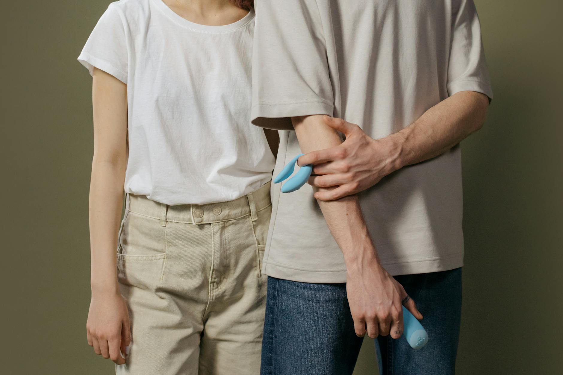 A couple exploring intimacy together with a blue vibrator, representing modern sexual wellness and connection.
